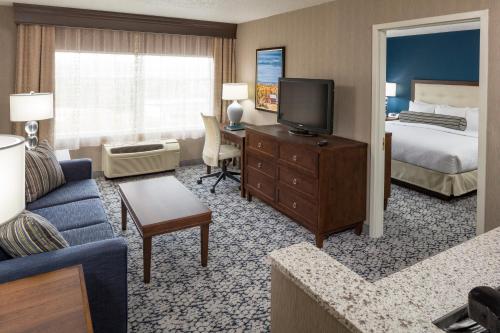 a hotel room with a bed and a living room at Inn at Middletown in Middletown