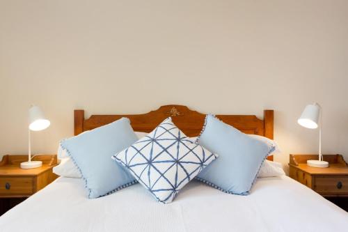 a bedroom with a white bed with blue pillows at Solhaven in Fremantle