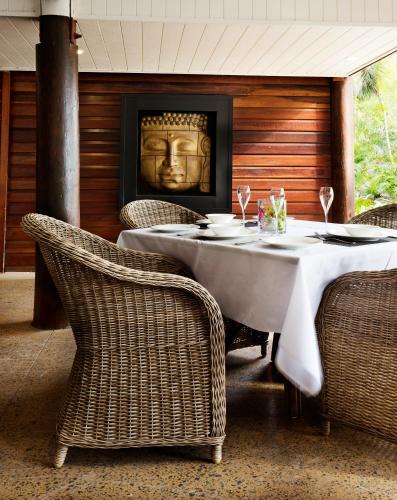 a dining room with a table and wicker chairs at Palm Bay Resort in Long Island
