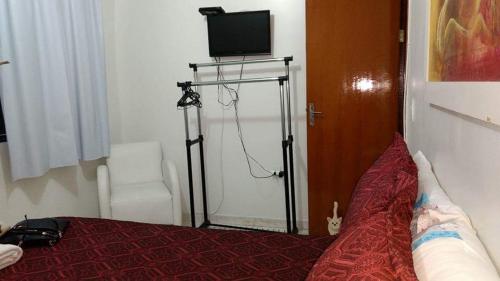 a bedroom with a bed with a television on a stand at Apartamento no Guará por temporada in Brasilia