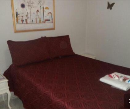 a bedroom with a bed with a red bedspread at Apartamento no Guará por temporada in Brasilia