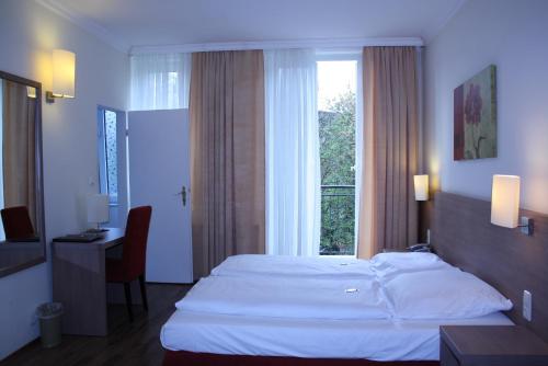 a hotel room with a bed and a window at Hotel Marienthal Garni in Hamburg