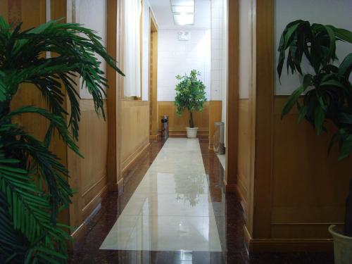 a hallway with two potted plants in a building at Qufu Garden Hotel in Qufu