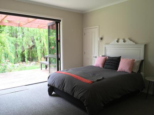 um quarto com uma cama e uma porta de vidro deslizante em Lye Bow Lake House em Alexandra