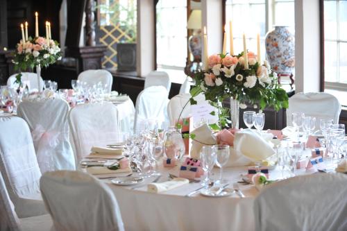 a table with white chairs and a table with flowers at Coombe Abbey Hotel in Coventry