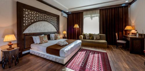 une chambre avec un grand lit et un salon dans l'établissement Orient Star Hotel, à Samarcande
