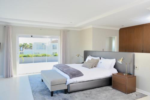 a bedroom with a bed and a large window at Grand Blue D in Cape Town