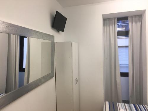 a bedroom with a mirror and a dresser and a tv at Albergue Santiago Apostol in Logroño