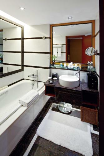 a bathroom with a sink and a tub and a mirror at Kempinski Hotel Shenzhen - 24 Hours Stay Privilege, Subject to Hotel Inventory in Shenzhen