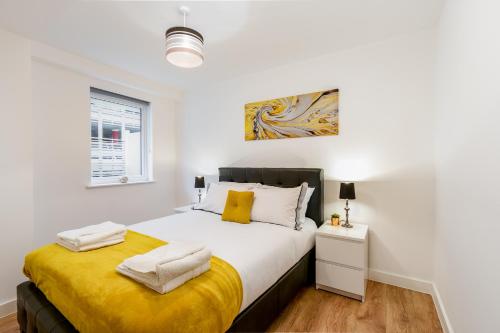 a bedroom with a large bed with a yellow blanket at Skyvillion - COZY APARTMENTS in Enfield Town With Free Parking & Wifi in Enfield