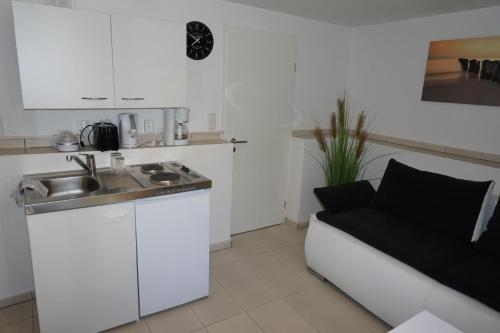 a kitchen with a sink and a couch in a room at Souterraine-Findlinge in Breege