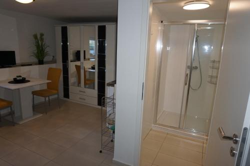a bathroom with a shower and a table and chairs at Souterraine-Findlinge in Breege