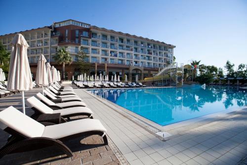 un hotel con una piscina con sillas y sombrillas en Washington Resort Hotel & Spa, en Kizilagac