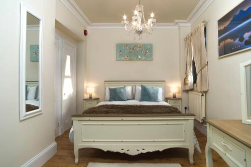 sypialnia z dużym łóżkiem i żyrandolem w obiekcie The Lodge at Heathfield w mieście Ledbury