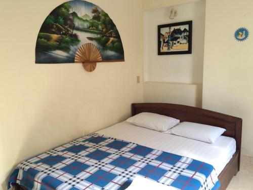 1 dormitorio con 1 cama y una pintura en la pared en Giang Hotel, en Ho Chi Minh