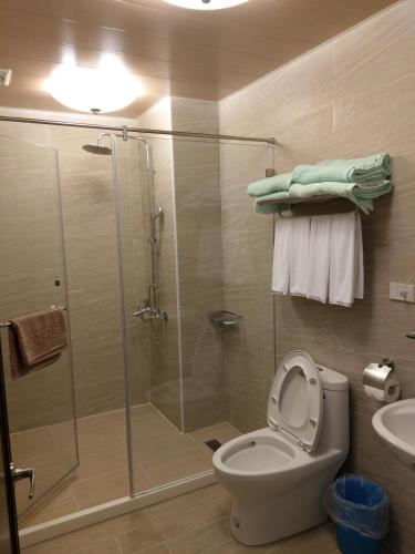 a bathroom with a shower and a toilet and a sink at Yan Sha Wan B&B in Taitung City