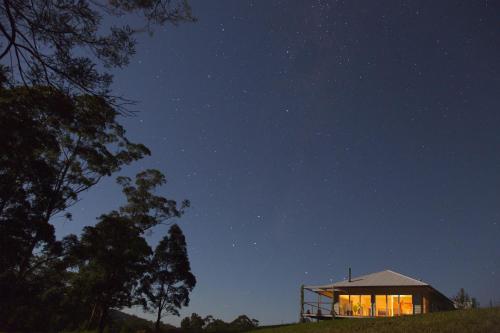 a house on a hill at night with the sky at Wilderberry Cottage in Berry
