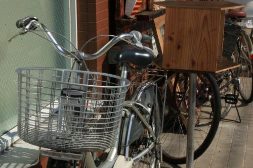 a bike with a basket parked next to a table at Ikkyu For Backpackers 19 in Hitoyoshi