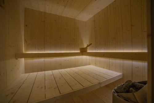 a small wooden sauna with a bench in it at Residence Cavanis Wellness & Spa in Sappada