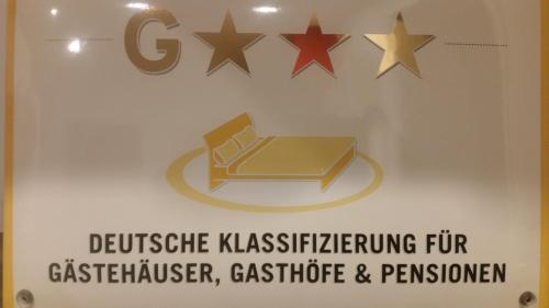 a sign with four stars on a wall at Pension Am Dorfanger in Hohennauen