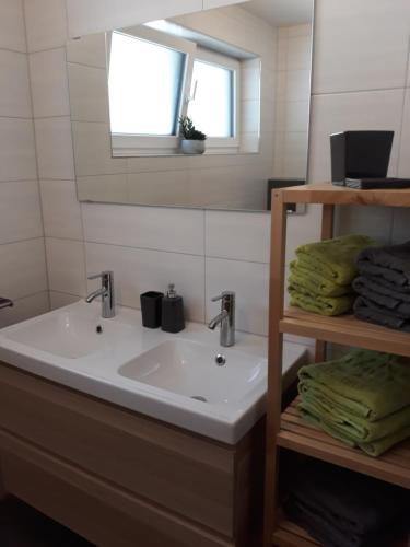ein Bad mit einem Waschbecken, einem Fenster und Handtüchern in der Unterkunft Apart Alpenflair in Sankt Leonhard im Pitztal