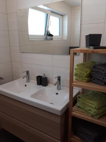 a bathroom with a sink and a window and towels at Apart Alpenflair in Sankt Leonhard im Pitztal