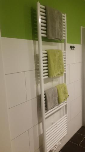 a bathroom with green and white towels and a mirror at Pension Am Dorfanger in Hohennauen
