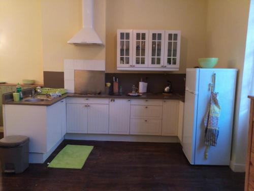  La cuisine est équipée de placards blancs et d'un réfrigérateur. dans l'établissement Lougat la maison des chats, à Cordes-sur-Ciel