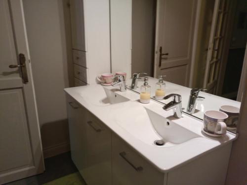 ein weißes Badezimmer mit 2 Waschbecken und einem Spiegel in der Unterkunft Lougat la maison des chats in Cordes-sur-Ciel