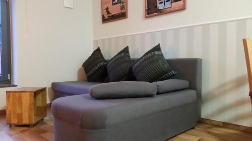 a couch with pillows on it in a living room at Pension Am Dorfanger in Hohennauen