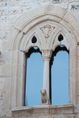 an arched window of a building with a statue at Hotel Corte Altavilla in Conversano