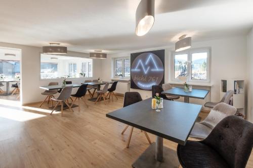 a dining room with tables and chairs and windows at bichl 761 in Fischen