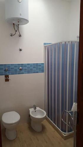 a bathroom with a toilet and a sink and a shower at Casa "da Paola" in San Vito lo Capo