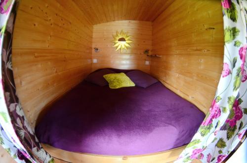 a small purple bed in a wooden sauna at Rosalie in Fiquefleur-Équainville