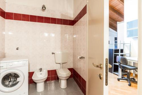 ein Badezimmer mit einem WC und einer Waschmaschine in der Unterkunft Emilia Levante 2, Bologna by Short Holidays in Bologna