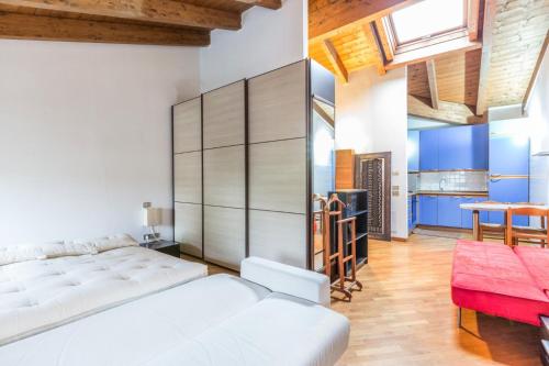 Schlafzimmer mit einem weißen Bett und einer roten Bank in der Unterkunft Emilia Levante 2, Bologna by Short Holidays in Bologna