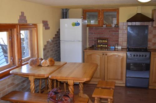 a kitchen with a table and a white refrigerator at Villa U Tsymbora in Sinyak