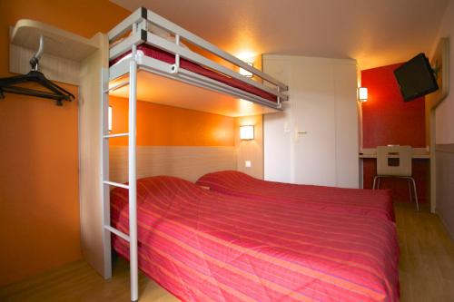 a bedroom with a bunk bed with a red bedspread at Premiere Classe Grenoble Nord Moirans in Moirans