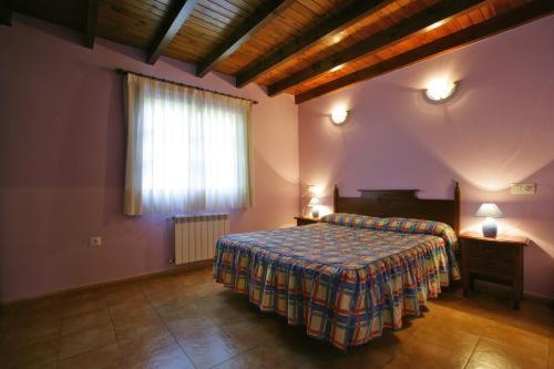 a large bedroom with a bed and a window at Apartamentos Picu Castiellu in La Galguera