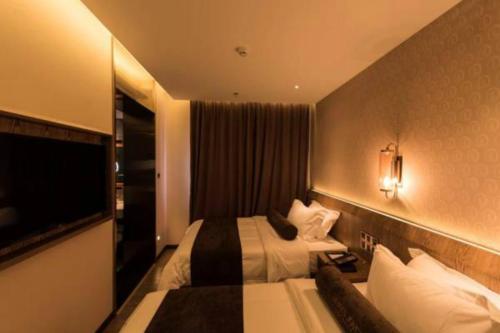 a hotel room with two beds and a television at James Joyce Coffetel Beijing Gulou street, Nanluoguxiang in Beijing