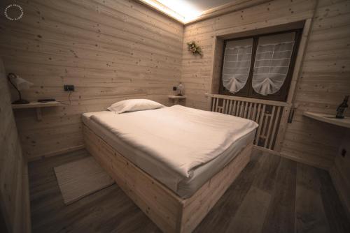 1 dormitorio con 1 cama en una habitación de madera en B & B Le Riue, en Aprica