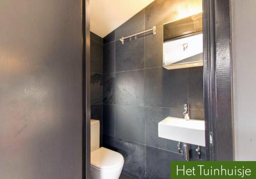 y baño con aseo blanco y lavamanos. en Garden House, Private studio apartment with wifi and free parking for 1 car, en Weesp