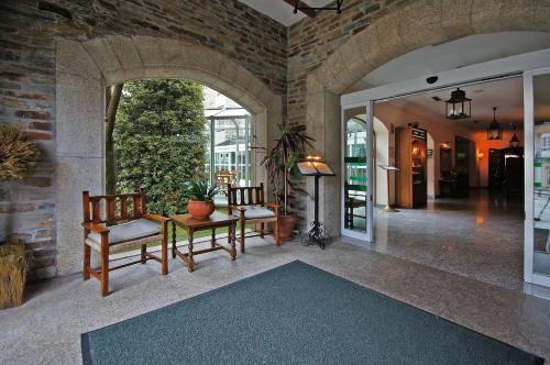 a living room with two chairs and a table at Parador de Vilalba in Villalba