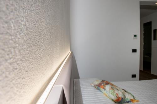 a bedroom with a bed with a white wall at Conero Suites in Numana