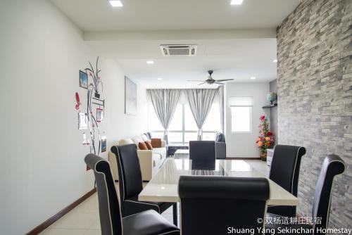 a dining room and living room with a table and chairs at Shuang Yang Sekinchan Homestay in Sekincan