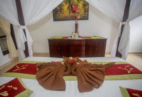 a stuffed animal laying on top of a bed at Balangan Sea View Bungalow in Jimbaran