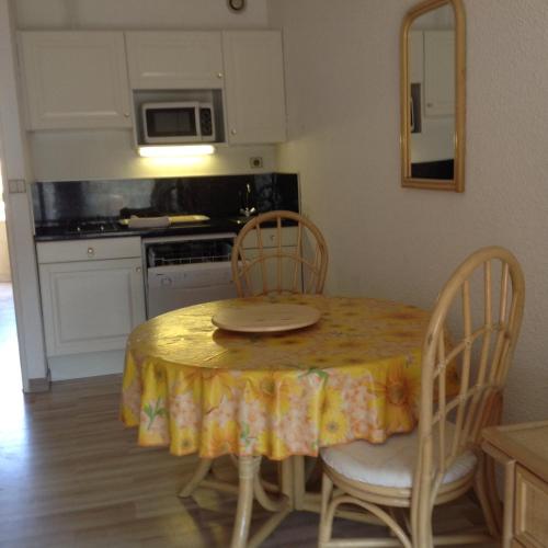 une cuisine avec une table et un chiffon de table jaune dans l'établissement Cavalaire chez Michelle, à Cavalaire-sur-Mer