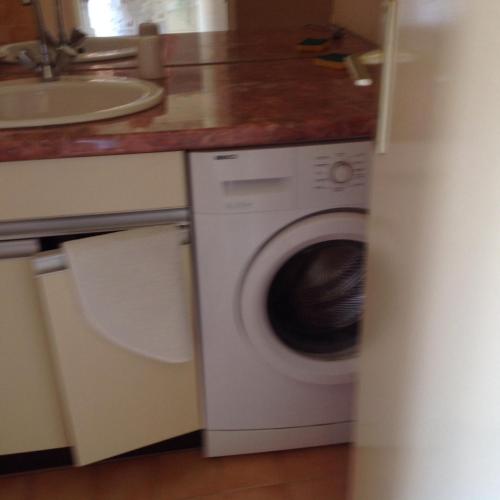 uma cozinha com uma máquina de lavar roupa e um lavatório em Cavalaire chez Michelle em Cavalaire-sur-Mer