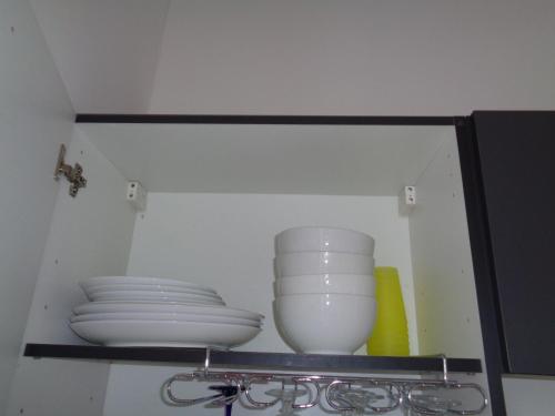 a shelf with plates and bowls in a cabinet at vacances 34 in Le Crotoy