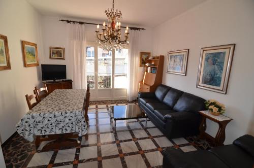 uma sala de estar com uma mesa e um sofá em Glicine apartment em Levanto